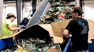 Two men sorting electronics for recycling
