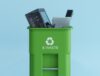 Green e-waste recycling bin filled with old electronics.