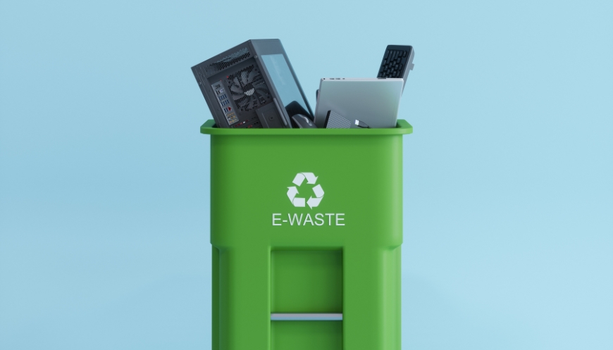 Green e-waste recycling bin filled with old electronics.