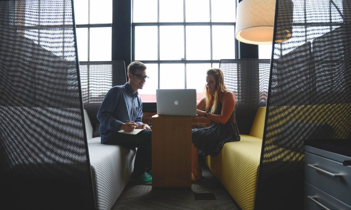 Two people collaborate at a modern office table, reflecting Dynamic Lifecycle Innovations’ focus on IT asset management solutions.